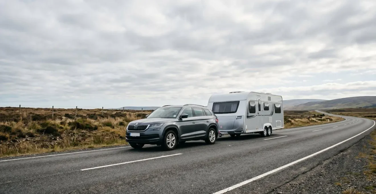 Wide angle view of a caravan being towed on a highway, demonstrating stable towing technique with proper weight distribution and balanced setup