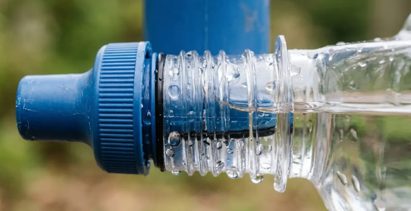 Macro detail of water bottle threads and filter connection point showing critical contamination zone