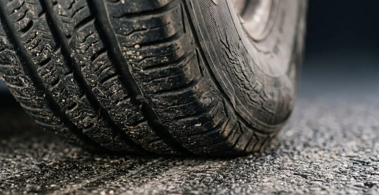 Extreme close-up macro shot of a tire sidewall under lateral stress showing textural deformation
